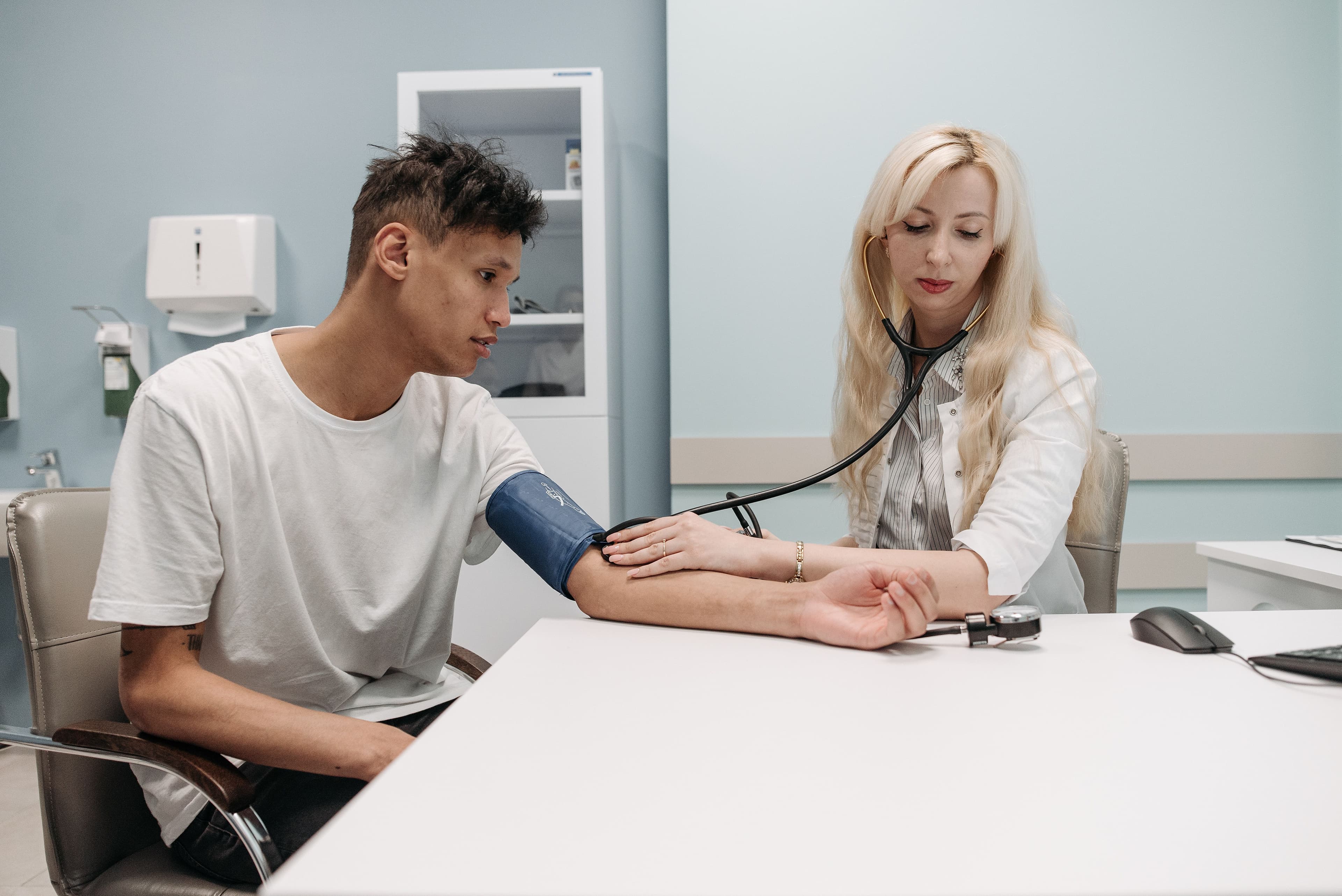 A doctor measures a patient-s blood pressure in a clinic setting