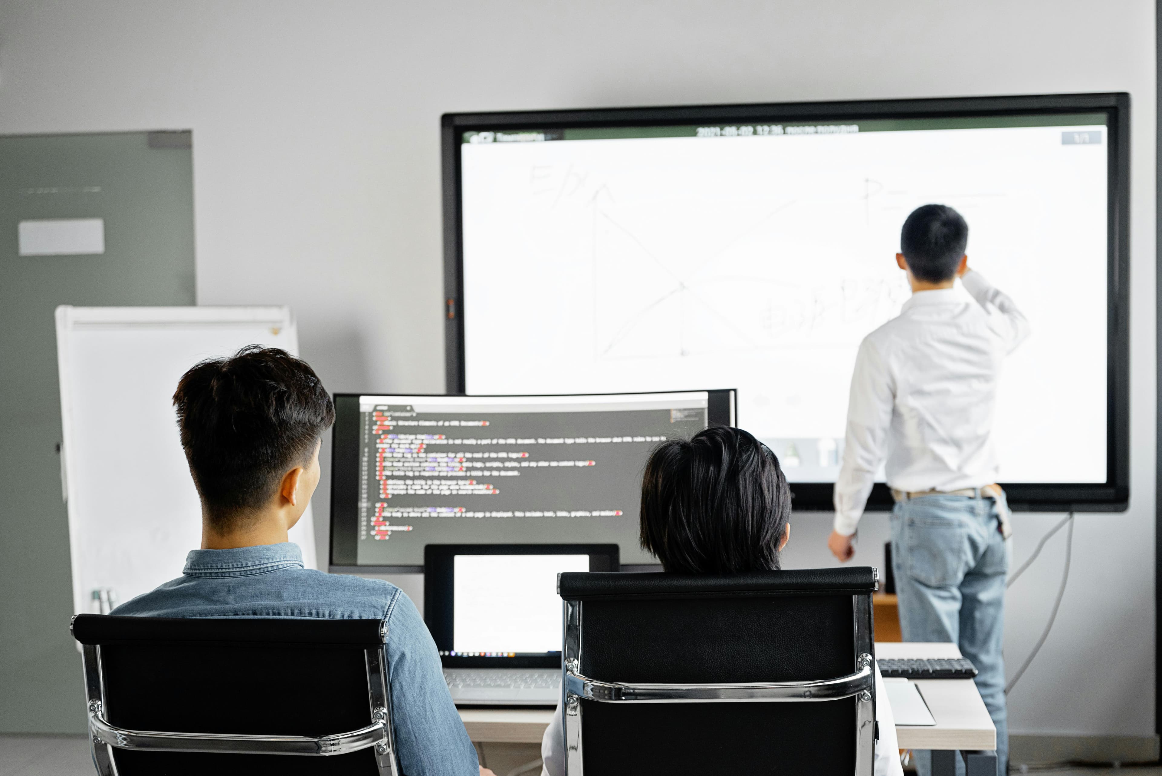 Team conducting a business presentation with technology in a modern office setting