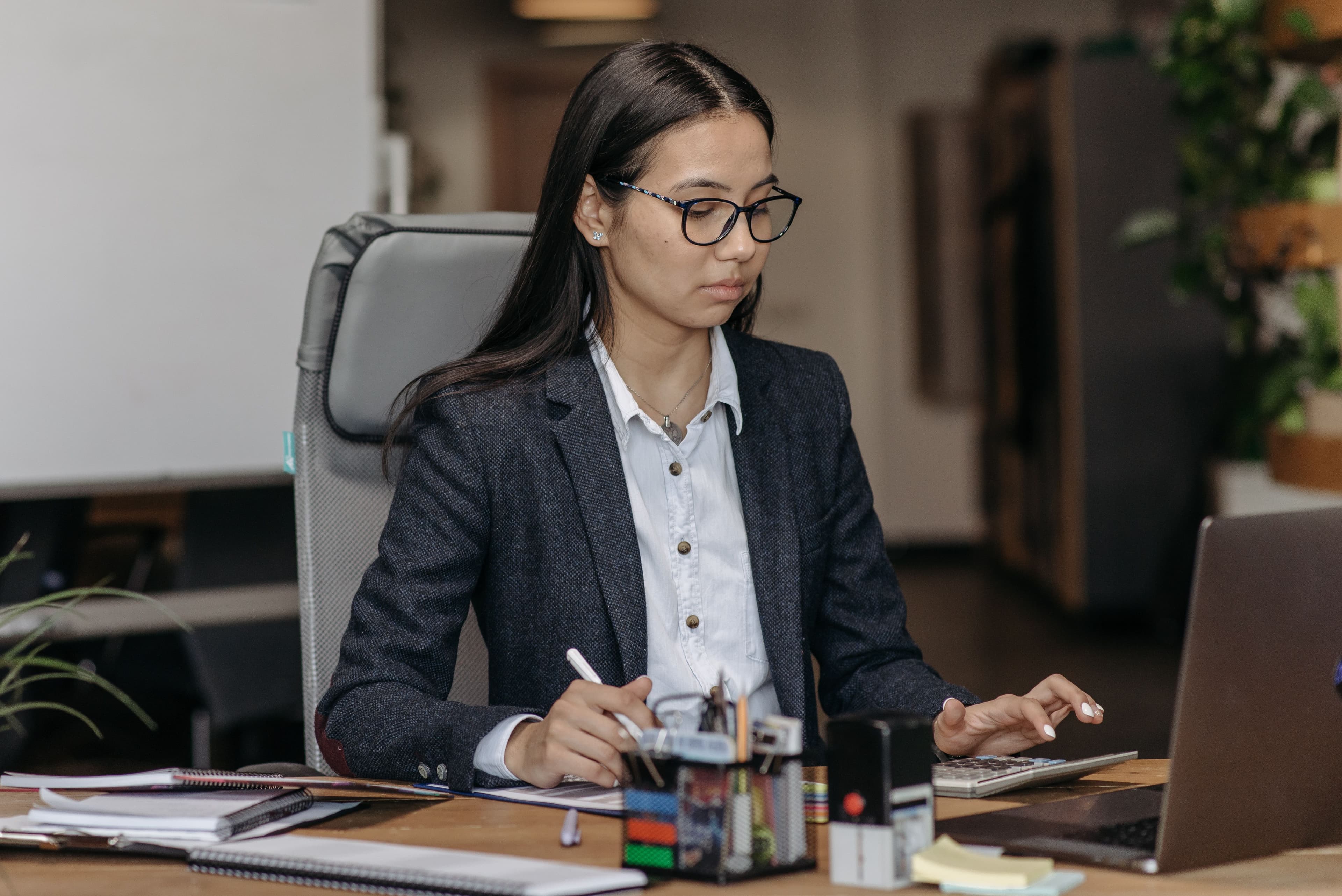 Young woman working with concentration at her laptop in a modern office setting