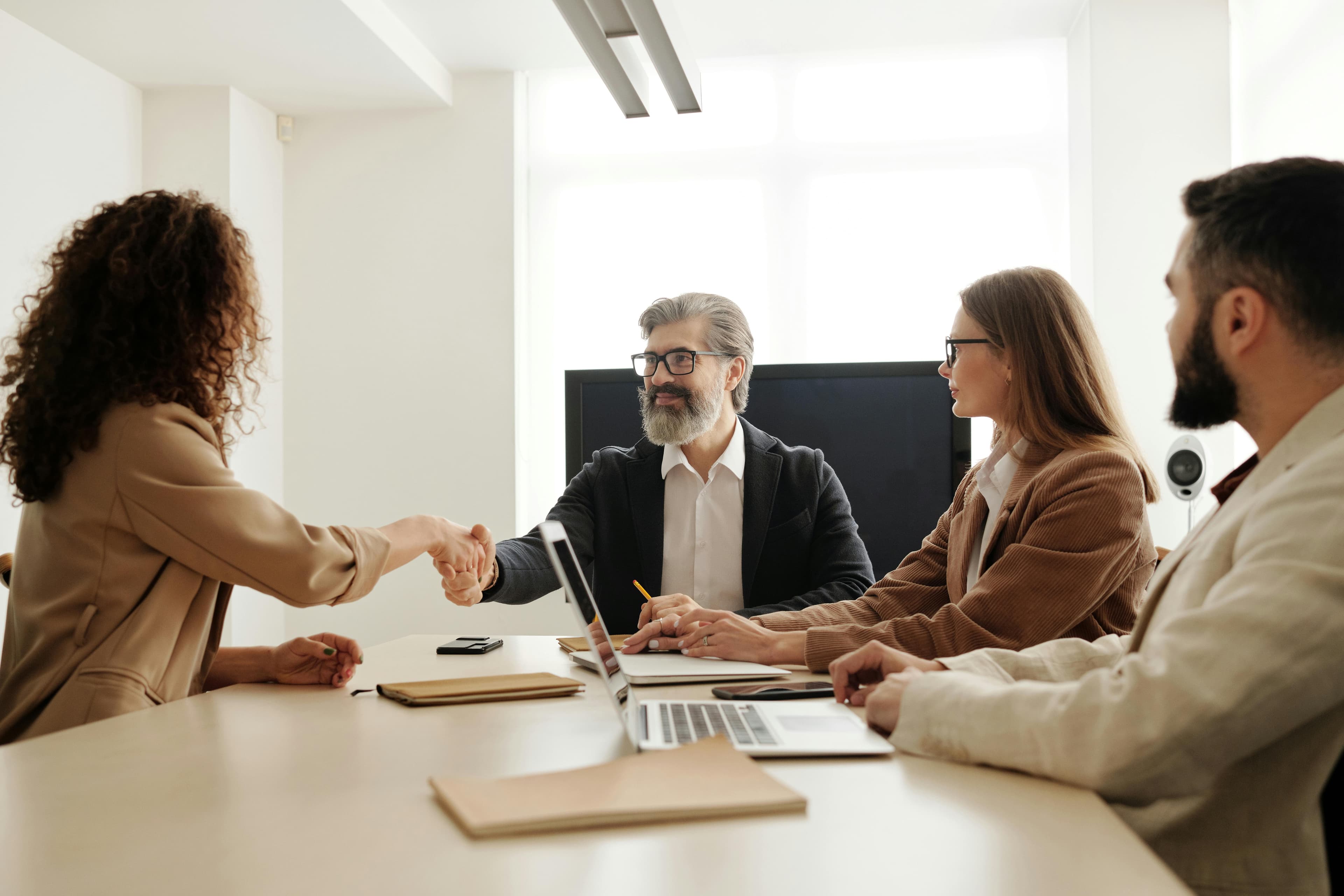 Colleagues in an office celebrating a successful negotiation with a handshake