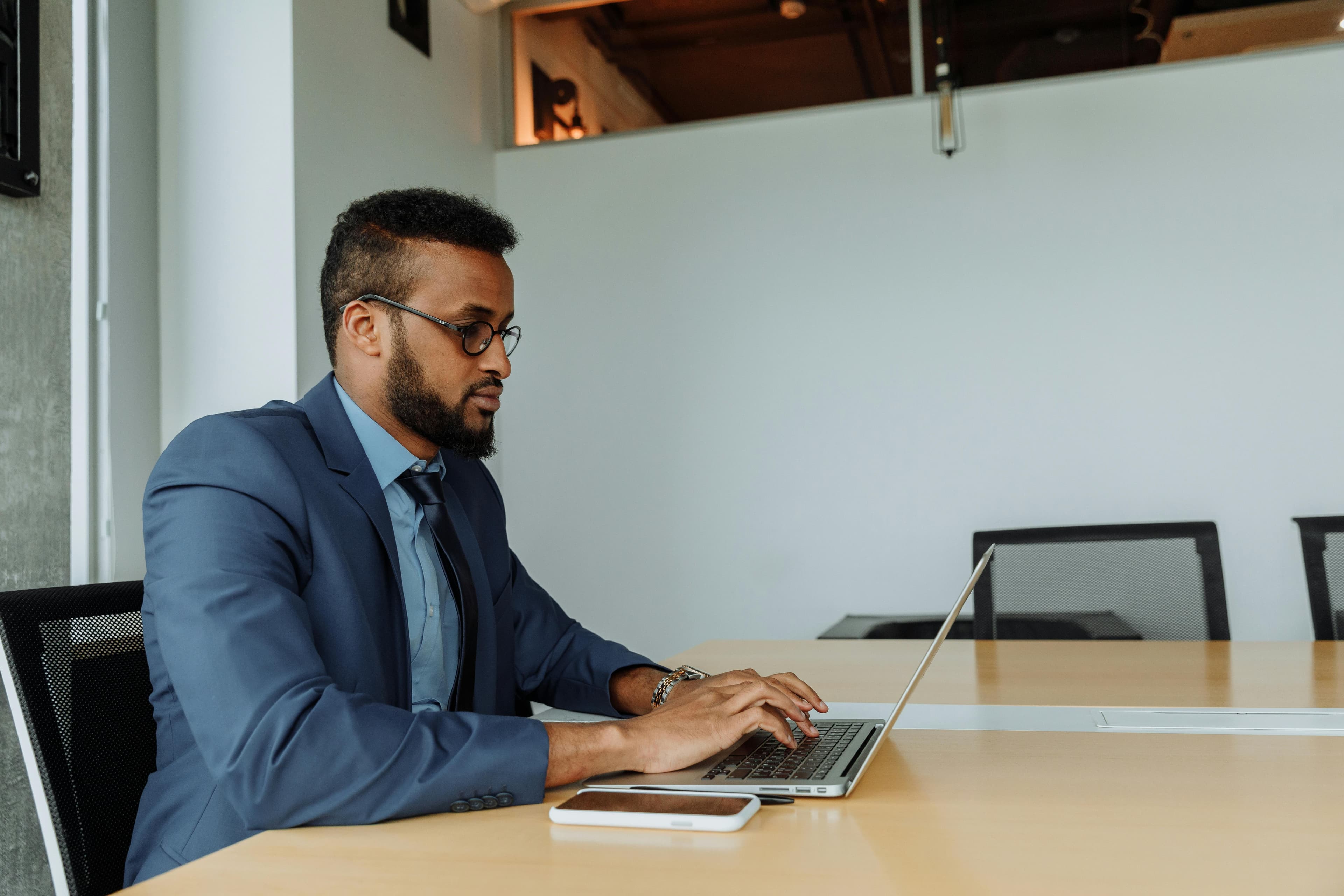 A man in a blue suit using a laptop