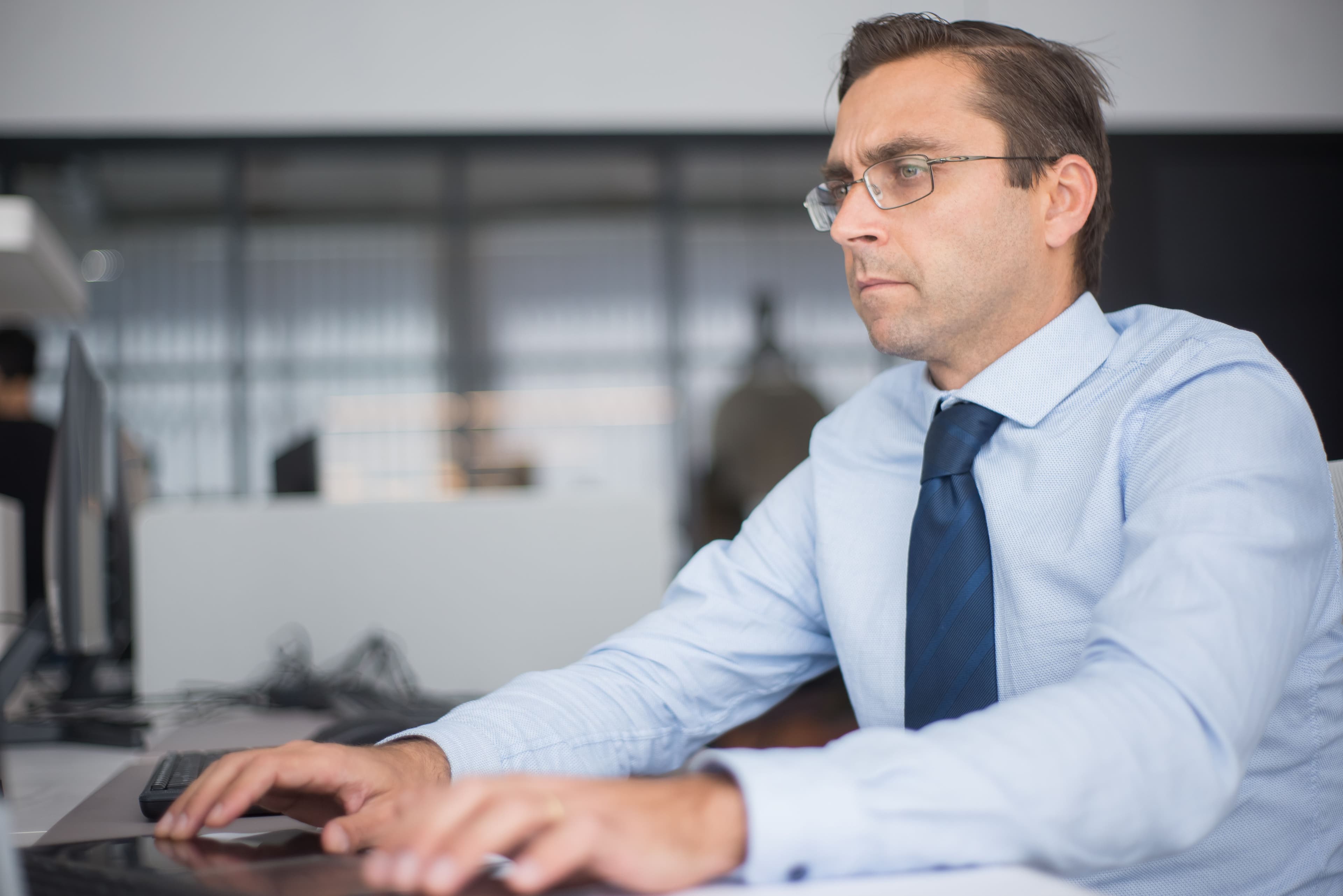Serious professional man working intensely at computer in office setting