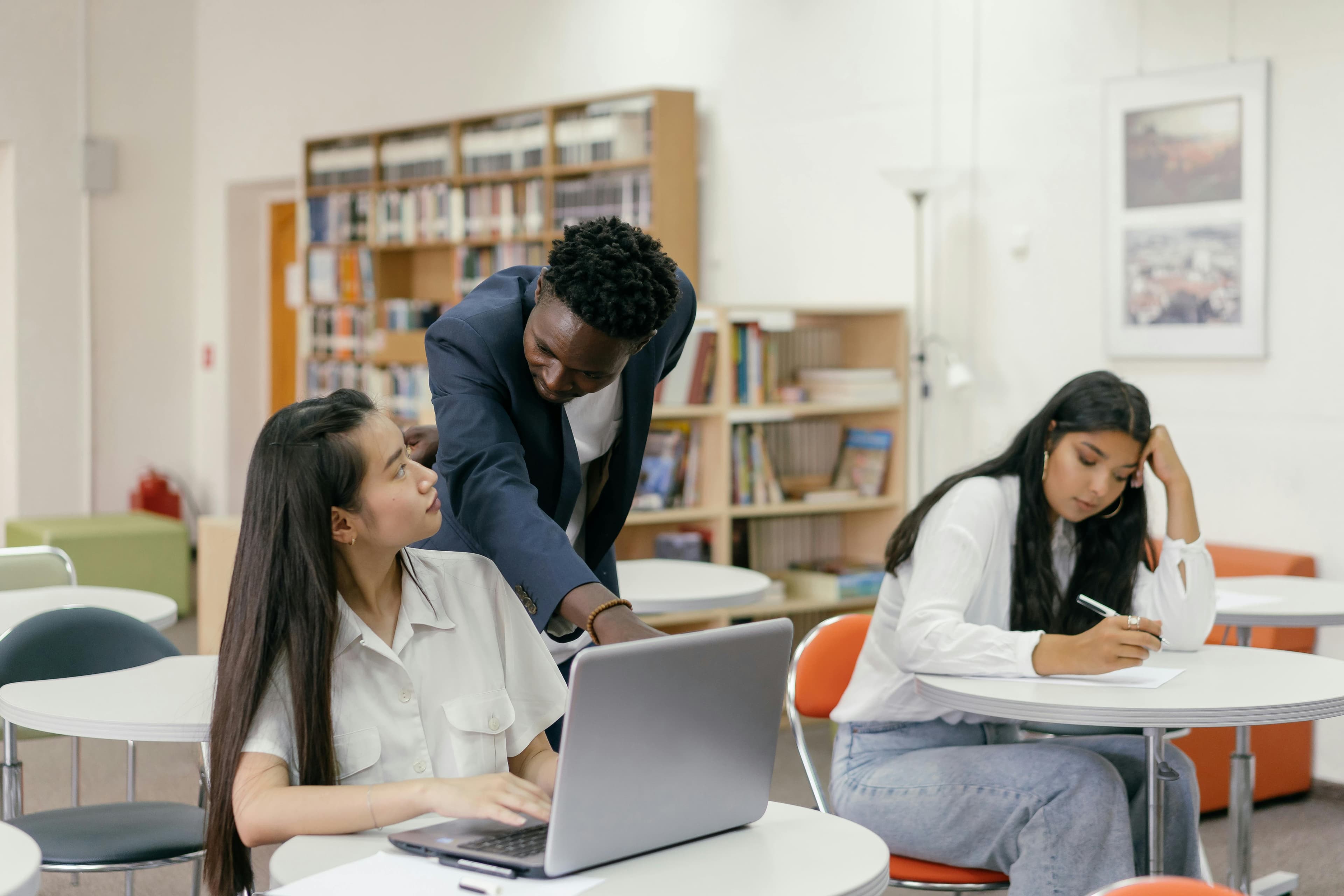 Students receiving guidance from a teacher in a well-equipped classroom