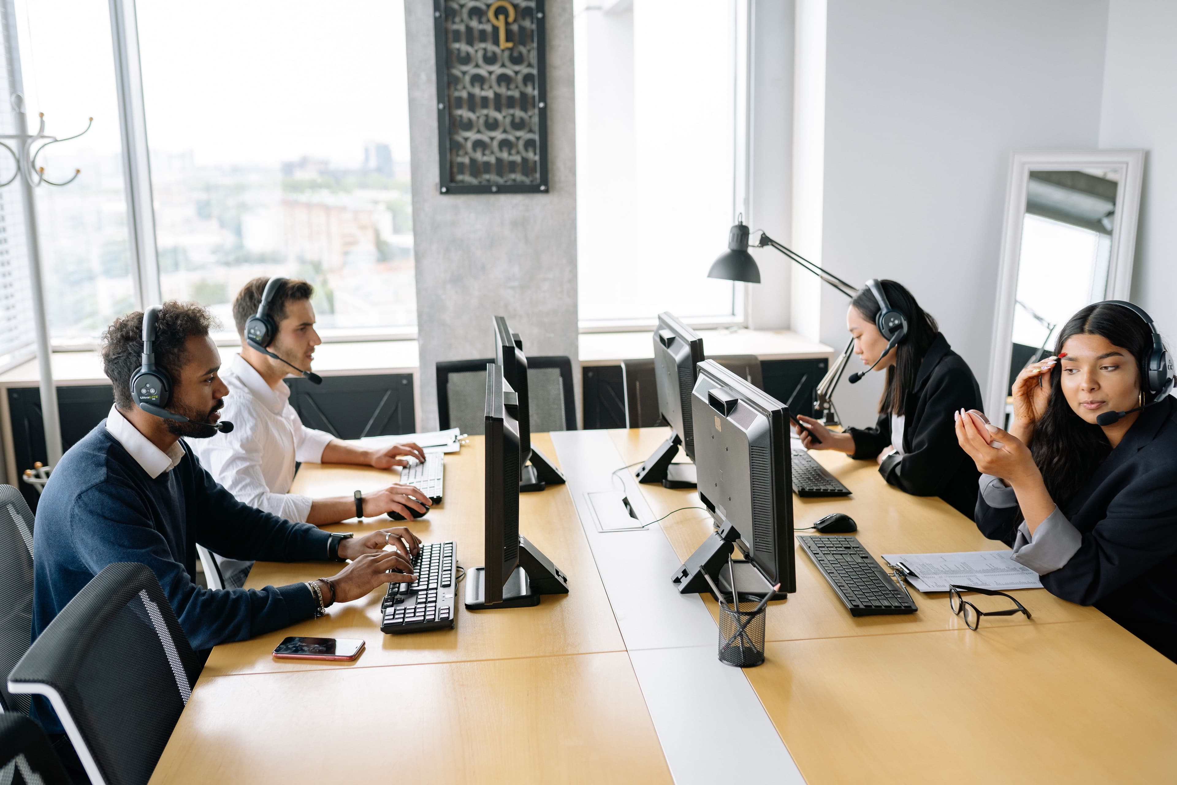 Group of professionals wearing headsets working at computer