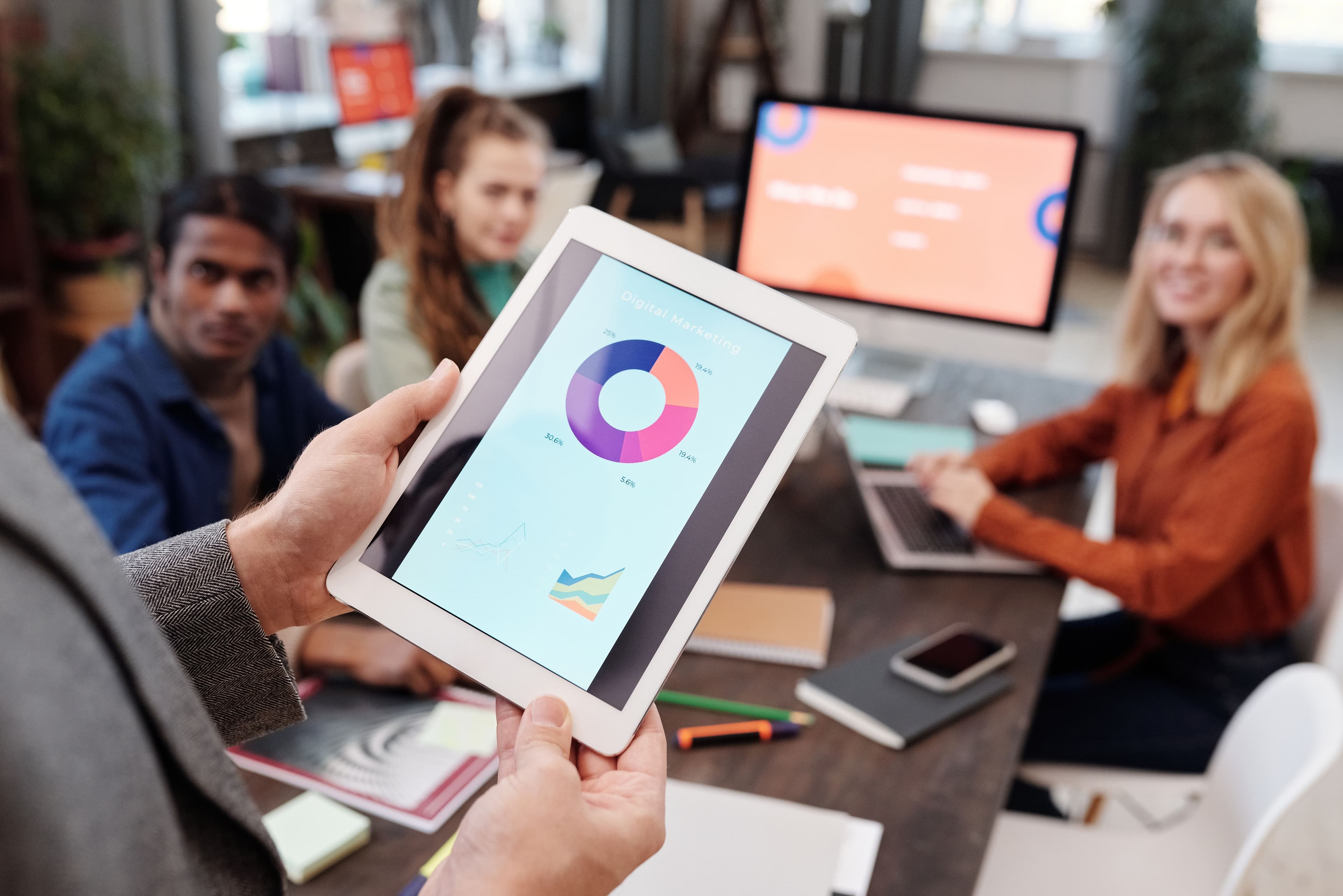 Business team using a tablet to analyze digital marketing data