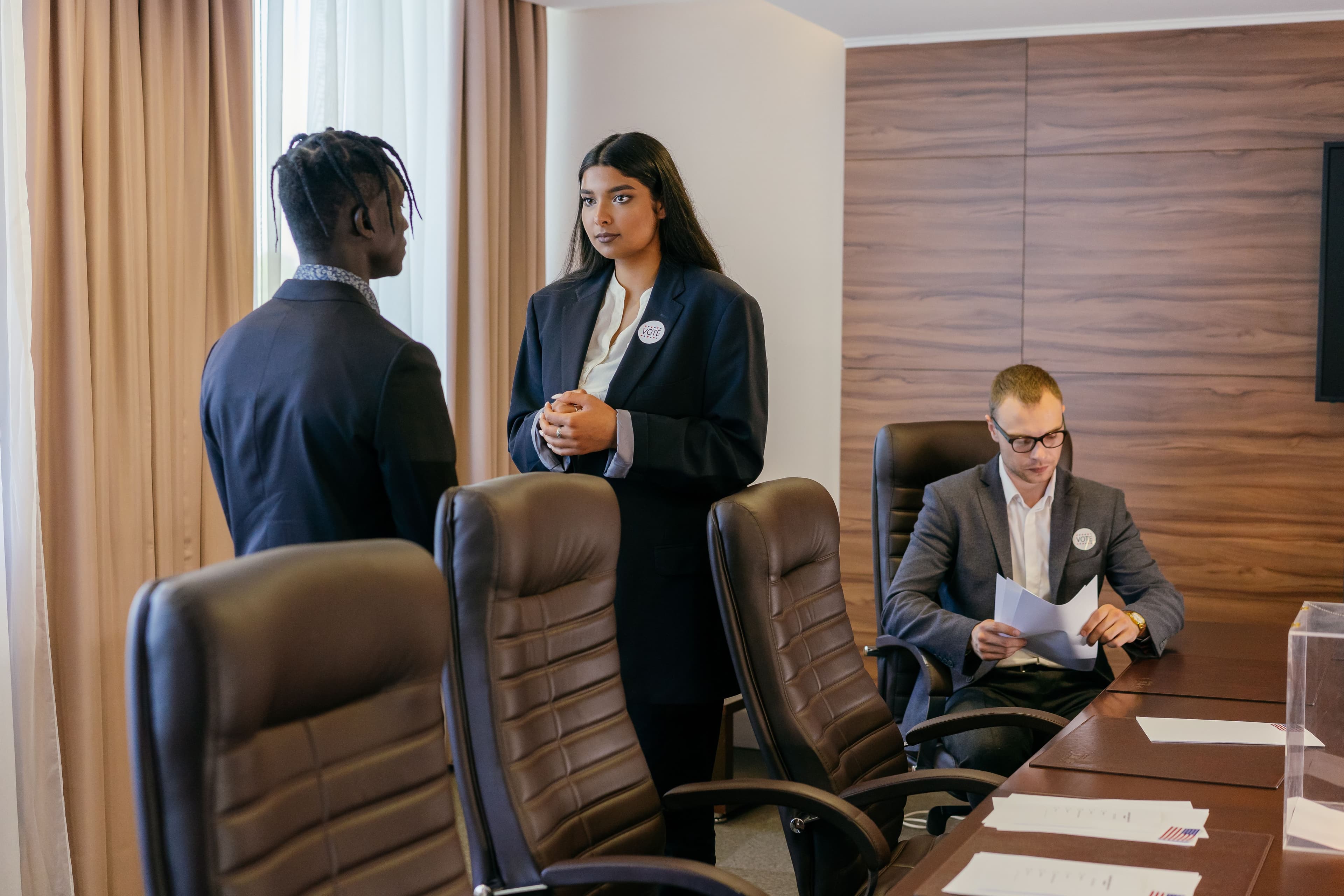 Three professionals discussing business strategy in a modern conference room