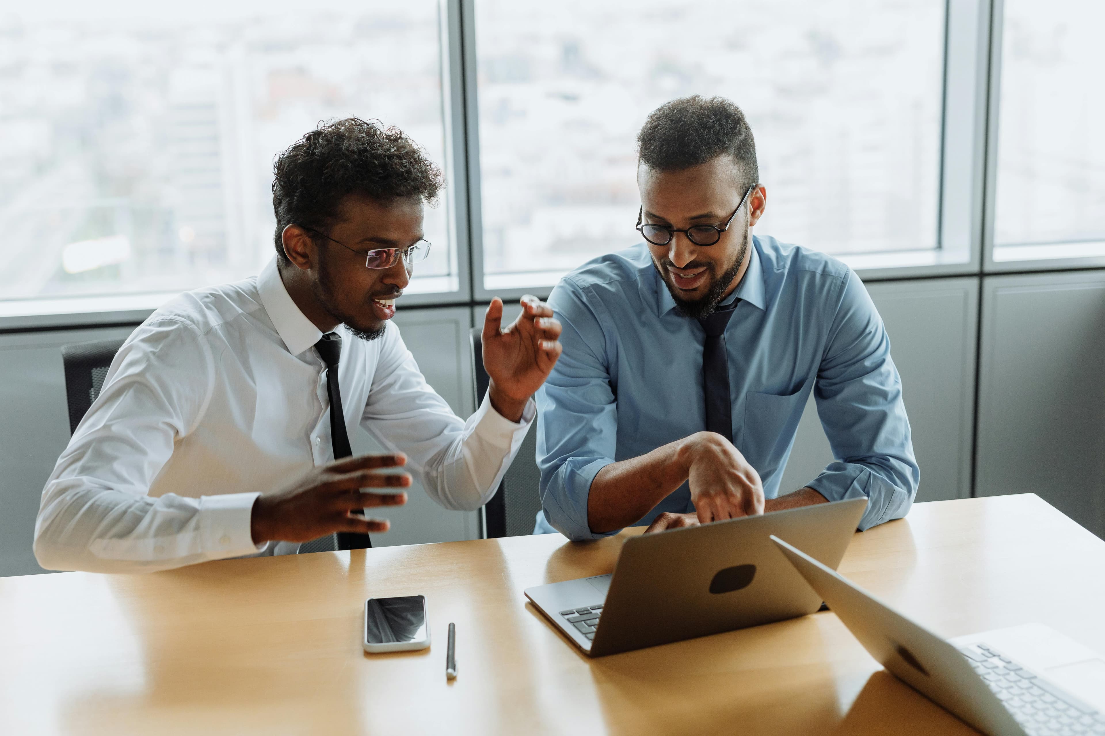 Men with laptop discussing with each other