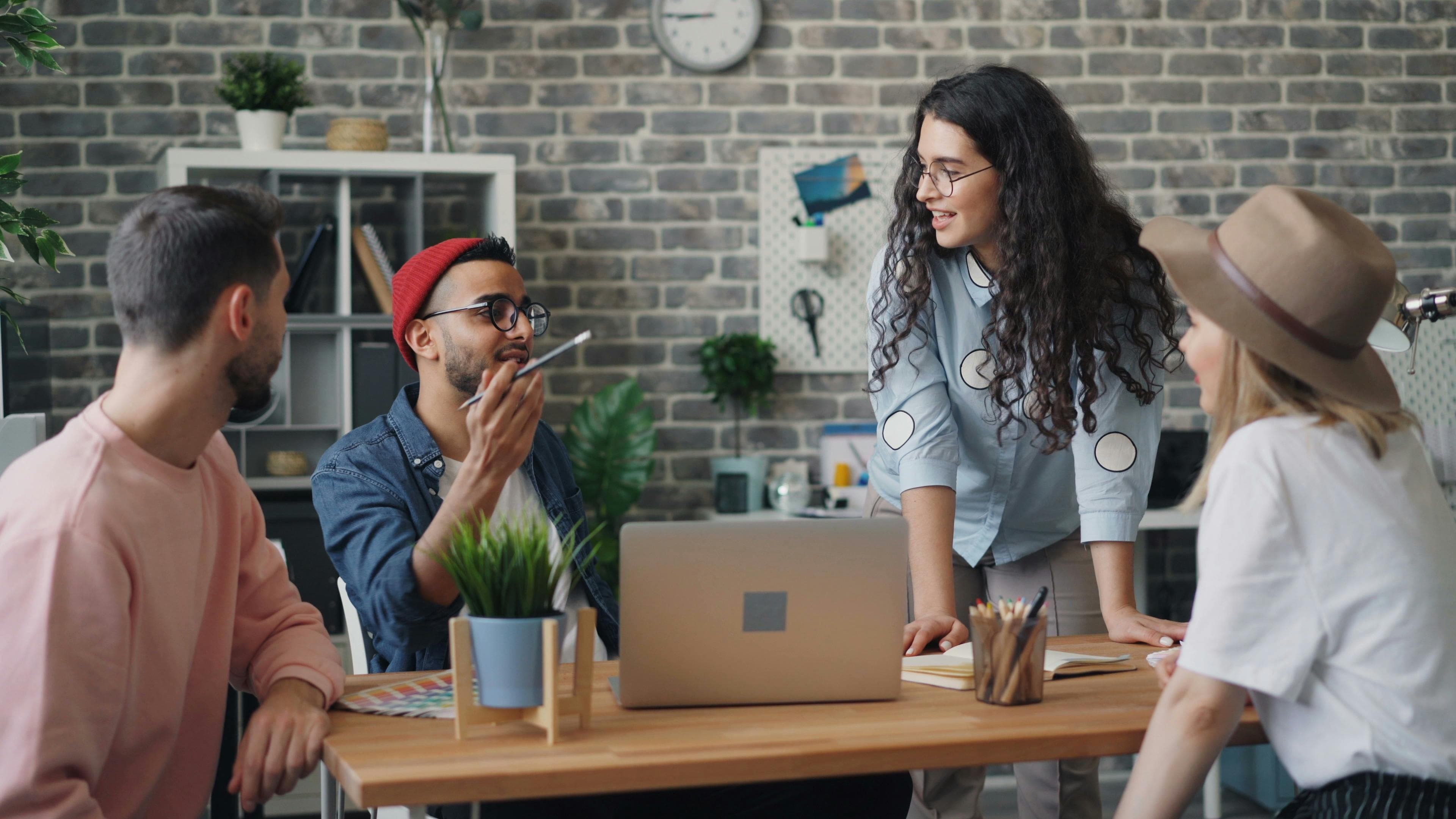 A diverse group of young professionals discussing a project in a stylish office setting