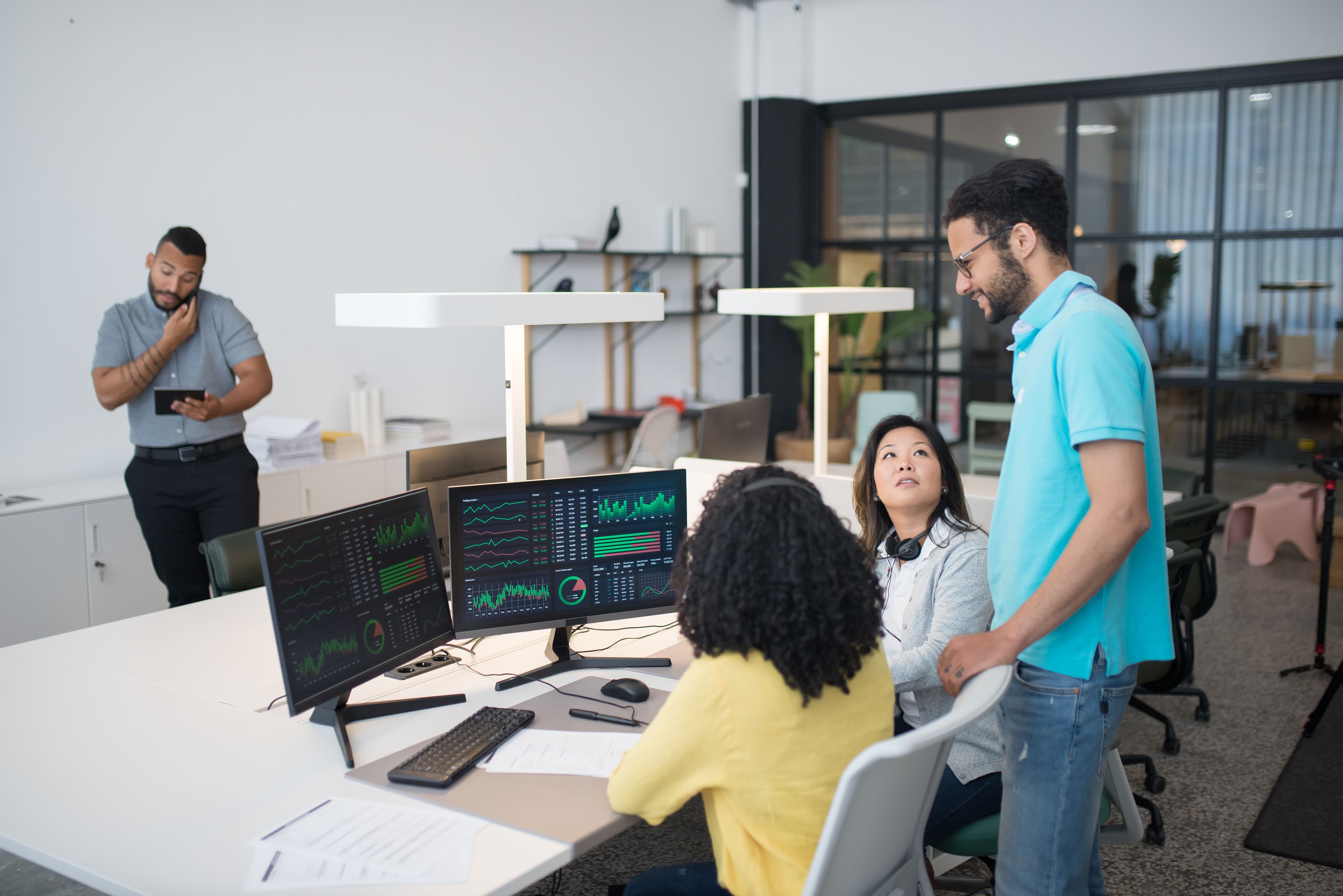 Office employees collaborate on financial data at modern workspace